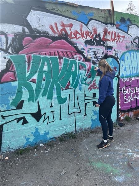 Graffitiverk med texten Kakao, en deltagare står bredvid